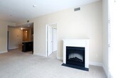 Located at 3100 N William Styron Square in Newport News, Virginia, this single-floor residence offers a well-designed layout with a thoughtful blend of comfort and modern style. The kitchen stands out as a focal point, showcasing rich dark espresso cabinetry, stainless steel appliances including a refrigerator, range, microwave, and dishwasher, complemented by granite countertops and a central island with light stone counters. Recessed lighting and tile flooring complete the sleek, functional space. In-unit laundry is conveniently accessible from the kitchen area. The open-concept living and dining area features plush carpeting, neutral warm tones, and an elegant chandelier, creating a bright and inviting atmosphere. French doors lead to natural light, while a fireplace adds a cozy focal point to the living space. The bedrooms are generously sized with soft carpeting, ceiling fans, and an abundance of natural light from multiple windows. Each bedroom offers ample storage with multiple closets featuring built-in rods and shelving. The bathrooms are clean and functional, with one featuring a white tub-shower combination with tiled surround, and another offering a vanity with dark countertop, white cabinetry, and stylish lighting. Neutral warm tones and clean finishes are carried throughout the entire residence.