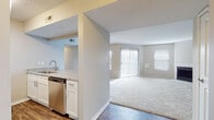 Located at 1300 Golf Club Ln in Cincinnati, Ohio, this single-floor residence offers a well-designed, open-concept layout that balances functionality with comfort. The living area is generously proportioned, featuring plush carpeting, a ceiling fan, a wood-burning fireplace, and multiple windows alongside a sliding glass door that floods the space with natural light. Neutral-toned walls throughout create a clean, cohesive aesthetic.

The kitchen is thoughtfully appointed with white cabinetry, granite-style countertops, a tile backsplash, and a full suite of stainless steel appliances including a refrigerator, electric range, over-the-range microwave, and dishwasher. Wood-look flooring in the kitchen adds warmth and durability. A peninsula with a sink connects the kitchen to the living area, reinforcing the open flow of the floor plan.

The bedrooms are carpeted and bathed in natural light from windows fitted with blinds, each offering closet storage. Two bathrooms serve the unit; the primary bathroom features granite-topped vanity cabinetry, wood-look flooring, and a walk-in closet area, while the secondary bathroom includes a tub and vanity with medicine cabinet storage. The overall ambiance is bright, neutral, and move-in ready.