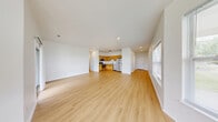 Located at 2 River Chase Dr. in Rensselaer, NY, this well-appointed single-floor home offers one bedroom, two bathrooms, and an efficient, thoughtfully designed layout. Light-toned hardwood flooring flows throughout the main living areas, creating a bright and cohesive aesthetic complemented by crisp white walls and recessed lighting.

The open-concept living, dining, and kitchen area forms the heart of the home. The living room features a bay-style window arrangement that invites generous natural light and provides views of the surrounding neighborhood. A glass door offers additional outdoor access. The kitchen is equipped with warm-toned wood cabinetry, light countertops, and a full suite of stainless steel appliances including a refrigerator, dishwasher, range, and microwave.

A hallway connects the main living area to the private bedroom, which is carpeted for comfort and includes direct access to one of the two bathrooms, which features a shower-tub combination. The second bathroom is conveniently accessible from the hallway. Multiple closets throughout provide ample storage. A dedicated laundry room and utility room add everyday convenience. The attached garage includes built-in shelving and an automatic opener, rounding out this practical and move-in-ready home.