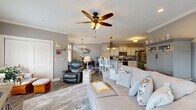 Located at 2500 7th Ave in Altoona, PA, this well-appointed 2-bedroom, 1-bathroom residence offers a thoughtfully designed single-floor layout that balances comfort and style. The open-concept great room seamlessly combines the living, dining, and kitchen areas into one inviting space. The living room features crown molding, a ceiling fan, hardwood-style flooring, and recessed lighting, creating a warm and welcoming atmosphere. The kitchen is a standout, showcasing cream cabinetry with dark hardware, dark granite countertops, a center island with a sink, and stainless steel appliances. An elegant arched passageway connects the entry hallway to the kitchen, adding a refined architectural touch. The dining area is bathed in natural light from a sliding glass door, accented by a chandelier overhead. The primary bedroom is a comfortable retreat with a ceiling fan, crown molding, and a window with outdoor views. The second bedroom functions well as a home office, complete with carpeted floors and a ceiling fan. The bathroom features tile flooring, a decorative vanity, and a serene, light blue color palette. Additional highlights include four closets, a utility room, and a hallway that connects all areas efficiently.