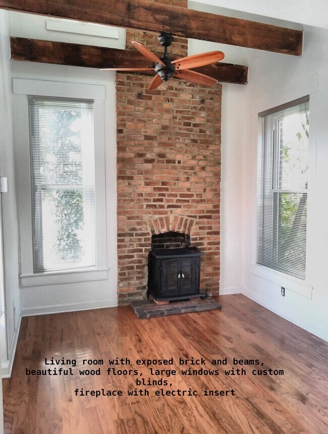 La sala de estar tiene grandes ventanales en 3 lados con ladrillos y vigas originales a la vista, chimenea eléctrica. - 810 E Washington St
