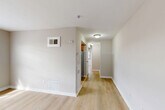 This one-bedroom, one-bathroom residence at 1625 Morris Rd SE in Washington, DC offers a thoughtfully laid-out single-floor plan. Light-toned hardwood flooring runs throughout, lending a clean and cohesive aesthetic to every room.

The combined living and dining area serves as the heart of the home, with natural light streaming through large windows fitted with blinds. Neutral warm-gray walls and crisp white trim create a bright, welcoming ambiance. A wall-mounted HVAC unit and floor vents ensure year-round comfort.

A central hallway connects the main living spaces to the bedroom, bathroom, and kitchen, providing a logical flow through the home. The kitchen is positioned off the hallway and features stainless steel appliances. Three closets distributed throughout the unit offer generous storage.

The bedroom is a well-proportioned, quiet retreat with a window overlooking greenery, neutral walls, and light hardwood floors. A set of bi-fold closet doors provides convenient wardrobe storage.

The bathroom is finished with white tile wainscoting, a gray vanity with a white sink, a mirrored medicine cabinet, and a full bathtub/shower combination. A window provides natural light and ventilation. A utility room rounds out the layout, adding practical functionality to this efficiently designed Washington, DC residence.