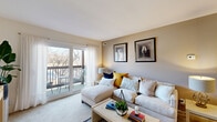 This thoughtfully laid-out 1-bedroom, 1-bathroom unit offers a functional and inviting floor plan across a single level. The living room serves as the heart of the space, featuring warm neutral tones, soft carpet underfoot, and a ceiling fan overhead. A sliding glass door opens to a private balcony, flooding the room with natural light and providing pleasant outdoor views. The living area flows seamlessly into a dedicated dining nook with hardwood-style flooring, complete with a ceiling fan and bar-height seating.

The galley kitchen is efficiently designed with warm wood cabinetry, white appliances including a refrigerator, range, and built-in microwave, along with ample counter space and a single-basin sink. Hardwood-style flooring continues throughout, adding cohesion and ease of maintenance.

The bedroom is a tranquil retreat, offering carpeted floors, a ceiling fan, a large double-door closet, and a window with sheer curtains that welcome natural light. The full bathroom features a vanity with a wide mirror, tile flooring, and a shower-tub combination, finished in clean, neutral tones. A hallway connects all rooms, enhancing the efficient flow of the overall layout.
