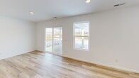 Located at 3782 Thunderhawk Pass in Fort Wayne, Indiana, this single-story, 3-bedroom, 2-bathroom home offers a clean, modern design with a bright and open feel throughout. Light-toned hardwood-style flooring runs continuously through the main living areas and bedrooms, complementing the crisp white walls and recessed lighting that keep every room feeling fresh and well-lit.

The heart of the home is a spacious open-concept area combining the kitchen, dining, and living spaces. The kitchen is outfitted with white shaker-style cabinetry, light countertops, stainless steel appliances including a refrigerator with ice maker, built-in microwave, and range, and a central island with a sink — ideal for both cooking and casual dining. A pantry provides additional storage. Sliding glass doors from the living area open to a patio with views of the surrounding neighborhood.

The primary bedroom is generously sized, with its own closet space. Two additional bedrooms offer versatility for guests, a home office, or family use. Six closets throughout the home ensure ample storage. Both bathrooms feature white vanities and tub-shower combinations with light flooring. A dedicated laundry room includes a full-size washer and dryer. The attached garage is spacious and finished with drywall and an automatic opener.