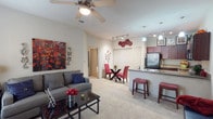 This single-floor residence offers a thoughtfully designed open-concept layout that seamlessly connects the living, dining, and kitchen areas. The living room is a welcoming space finished with plush carpeting, a ceiling fan, and generous window coverage that allows natural light to filter through. The open flow connects directly to a dedicated dining area, making the space feel cohesive and functional.

The kitchen is well-equipped and visually striking, featuring rich dark wood cabinetry extending to the ceiling, granite-style countertops, and a full suite of black appliances including a refrigerator, range, microwave, and dishwasher. Light wood-style flooring grounds the kitchen, while pendant lighting and track lighting illuminate the space effectively. A breakfast bar with seating bridges the kitchen and living area, adding both functionality and an informal dining option.

The bedroom is a comfortable retreat with carpeted flooring, a ceiling-mounted light fixture, and a walk-in closet offering ample storage. Windows allow natural light while maintaining privacy. The full bathroom features wood-style tile flooring, a dark wood vanity with granite countertop, and a well-lit mirror above the sink. The overall ambiance of the residence is warm and functional, with a consistent design palette throughout.