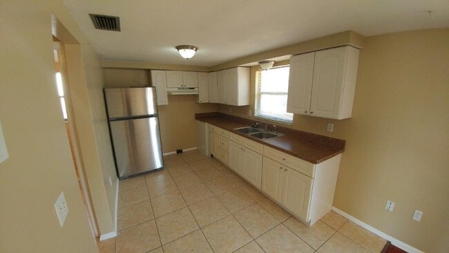 Building Photo - Large 2/2/1 1060 sq ft home with INDOOR LAUNDRY, a full garage, updated kitchen and a fenced in y...