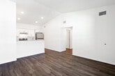 Located at 915 Ariana St in Lakeland, Florida, this single-story unit offers a clean, modern aesthetic throughout. The open-concept living area features light-toned wood-look flooring that extends seamlessly across the space, complemented by crisp white walls and recessed lighting that create a bright, airy atmosphere.

The kitchen is a standout feature, designed with white shaker-style cabinetry, granite-look countertops, and a full suite of stainless steel appliances including a refrigerator and electric range. A peninsula with a built-in sink provides additional prep space and serves as a natural divider between the kitchen and living area. Conveniently tucked adjacent to the kitchen is an in-unit stacked washer and dryer.

The bedrooms are generously proportioned, each finished with the same warm wood-look flooring and neutral wall tones. Large windows allow ample natural light to fill these rooms, enhancing the sense of openness.

The bathrooms maintain the same refined design language, featuring white shaker vanities topped with granite-look counters, wood-framed mirrors with brushed nickel fixtures, and full tub-shower combinations with clean white surrounds. Wood-look flooring carries through these spaces as well, tying the overall aesthetic together cohesively throughout the unit.