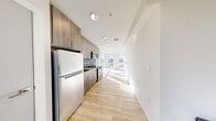 Located at 1942 S Fawcett Ave in Tacoma, WA, this thoughtfully designed 2-bedroom, 1-bathroom unit offers a modern aesthetic with a highly functional layout. Light-toned hardwood flooring runs throughout, creating a cohesive and airy feel across every room.

The open-concept kitchen and living area serves as the heart of the unit. The kitchen is outfitted with warm wood-grain cabinetry, a mosaic tile backsplash, stainless steel appliances including a range and microwave, and a full-size refrigerator. The living area is anchored by dramatic floor-to-ceiling windows that flood the space with natural light and frame sweeping views of the Tacoma skyline and surrounding cityscape.

Both bedrooms are clean and bright, with large windows and sliding-door closets providing practical storage. The primary bedroom benefits from abundant natural light with a cozy, functional footprint.

The bathroom features light wood-tone cabinetry with open shelving, an integrated sink, a full soaking tub with shower, and matching flooring that ties the space together seamlessly. Additional conveniences include an in-unit laundry area and a dedicated pantry for extra storage. The overall ambiance is clean, contemporary, and light-filled, making excellent use of every square foot.