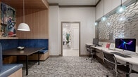 Located at 2350 8th Avenue South in Nashville, TN, this thoughtfully designed single-floor amenity space offers a dynamic and visually engaging environment across a generous footprint. The centerpiece of the main area is a large, curved white-topped island with warm wood base, surrounded by seating and illuminated by a playful cluster of multicolored pendant lights suspended from a bold, dark ceiling cutout. Light wood-look tile flooring and soaring ceilings amplify the sense of openness throughout.

The living room area features an eye-catching oversized curved sofa in a warm terracotta hue, positioned before a large flat-screen TV framed by a sculptural mosaic wall accent. Curated artwork and metallic wall sculptures add personality throughout. A separate seating lounge includes a sleek linear electric fireplace, teal upholstered chairs, and floor-to-ceiling windows that invite abundant natural light. A billiards table offers additional recreation space nearby.

The workspace area provides built-in desks with computer workstations, pendant lighting, and cozy blue-upholstered booth seating with warm wood paneling and vibrant mural accents. Textured patterned carpet anchors the more intimate zones, creating clear distinctions between social and focused-use areas. The overall ambiance balances modern sophistication with approachable, energetic style.