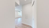 Located at 4225 SE Milwaukie Ave in Portland's vibrant Sellwood-Moreland neighborhood, this thoughtfully designed two-bedroom, two-bathroom residence offers a clean, modern aesthetic throughout. Light-toned hardwood-style flooring runs continuously across the entire unit, lending a cohesive and bright feel to each room.

The open-concept living and kitchen area serves as the heart of the home, bathed in natural light from large windows that frame views of the surrounding neighborhood's lush greenery. The contemporary kitchen features sleek white cabinetry, stainless steel appliances including a range, dishwasher, microwave, and refrigerator, all complemented by crisp countertops and a single-basin sink.

A connecting hallway leads to both bedrooms and bathrooms. The primary bedroom offers a comfortable footprint with a sliding-door closet. The secondary bedroom is bright with a window overlooking greenery, making it well-suited as a guest room, home office, or additional sleeping space.

Both bathrooms maintain the unit's clean design language, featuring white vanities with under-cabinet storage, tub-shower combos with chrome fixtures, and wood-style flooring. Recessed lighting throughout keeps the space feeling open and modern. The overall ambiance is fresh, minimal, and move-in ready.
