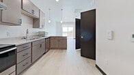 Unit 522 at 808 Melvin Ct in Madison, Wisconsin offers a thoughtfully designed 1-bedroom, 1-bathroom layout across 580 square feet of single-floor living space. The unit features light wood-tone luxury vinyl plank flooring and crisp white walls with bold dark baseboards throughout, creating a clean, contemporary aesthetic.

The kitchen is well-appointed with taupe cabinetry, stainless steel appliances including an electric range and refrigerator, a double-basin sink, a dishwasher, and pendant lighting above the counter peninsula. Recessed lighting adds to the functional ambiance of the space.

The primary bedroom measures 140 square feet and is bathed in natural light through a large window offering outdoor views of the surrounding neighborhood. A ceiling fan provides additional comfort, and a dedicated closet provides practical storage.

The bathroom features light stone-look tile flooring, a full soaking tub with shower, and clean white walls accented by dark baseboards consistent with the unit's design language.

A sliding glass door visible from the kitchen/living area leads to a private balcony, bringing in additional natural light and outdoor connectivity. The open-concept flow between the kitchen and living area maximizes the efficient use of the 580-square-foot floor plan, making this unit an ideal modern residence.