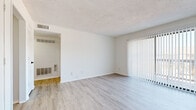 Located at 1935 S Swope Dr in Independence, MO, this single-floor, one-bedroom, one-bathroom unit offers a clean and functional layout designed for comfortable everyday living. The living room is a bright, open space finished with light-toned luxury vinyl plank flooring and features a full-height sliding glass door dressed with vertical blinds, allowing an abundance of natural light and providing views of the surrounding greenery. A textured ceiling adds subtle architectural detail throughout the main living areas. The kitchen is modern and efficient, highlighted by a peninsula with a light stone countertop, sleek gray flat-front cabinetry, a matte black faucet, and black appliances, all illuminated by a flush ceiling light fixture. Connecting hallways provide smooth flow between the living space and private quarters. The bedroom is a comfortable retreat featuring plush wall-to-wall carpeting, a ceiling fan with light, and a window dressed with blinds that brings in natural light. A dedicated closet adds practical storage. The bathroom is clean and well-equipped with a full tub-shower combo, a curved shower rod, a single-sink vanity with modern cabinetry, and matching LVP flooring, all finished in a crisp, neutral palette.