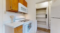 Located at 620 N Litchfield Rd in Goodyear, Arizona, this single-story home offers a practical and comfortable layout with consistent wood-look flooring running throughout every room. The kitchen is well-appointed with warm oak cabinetry, white countertops, and a full suite of white appliances including a gas range with over-the-range microwave, dishwasher, and refrigerator. A dedicated walk-in pantry adjacent to the kitchen provides generous shelving for additional storage. The living and entry areas are bright and open, with large windows that frame views of the surrounding greenery and allow abundant natural light to fill the space. Ceiling fans are featured in the living areas, adding to the home's functionality. The bedrooms are generously sized, each benefiting from multiple windows that enhance the airy feel, and at least one bedroom includes a walk-in closet with built-in shelving. The bathroom is cleanly finished with a vanity, mirror, toilet, and a shower-tub combination. Clean white walls and neutral tones throughout create a cohesive, move-in-ready aesthetic. The overall layout, as seen in the dollhouse view, is efficient and well-organized, making this a comfortable single-floor home in the heart of Goodyear.