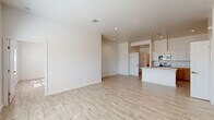 Located at 5602 Shadow Hills Rd in Las Cruces, NM, this single-story, 3-bedroom, 2-bathroom home offers a clean, contemporary design throughout. Light wood-look flooring extends across the open-concept living, dining, and kitchen area, creating a bright and cohesive feel. Tall ceilings amplify the sense of space, while recessed lighting and large windows invite abundant natural light.

The kitchen is a standout feature, outfitted with stainless steel appliances including a French door refrigerator, electric range, built-in microwave, and dishwasher. Two-toned cabinetry — white upper cabinets paired with warm wood-toned lower cabinets — surround generous counter space, complemented by a center island with a stainless steel sink and white quartz countertops. A dedicated pantry closet provides additional storage.

The spacious primary bedroom features a walk-in closet and access to a private bathroom, complete with a single-sink vanity with warm wood cabinetry, a large framed mirror, and wood-look tile flooring. The second bathroom includes a full tub-shower combination and a matching vanity. Two additional bedrooms offer comfortable proportions, closets, and natural light. A dedicated laundry area rounds out the functional layout of this well-designed home.