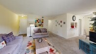 Located at 750 Gaines School Rd in Athens, GA, this single-floor residence offers a practical and comfortable layout across two bedrooms and three bathrooms. The living room features soft carpeting, neutral warm-toned walls, and a sliding glass door that invites natural light and outdoor views, creating an open and welcoming atmosphere. An open passage connects the living area to the dining space, which benefits from a large window overlooking greenery outside. The kitchen is efficiently designed with white cabinetry extending to the upper walls, a stainless steel sink, electric range with overhead ventilation, dishwasher, and refrigerator. A built-in shelving alcove adjacent to the kitchen provides convenient pantry-style storage. Both bedrooms are carpeted and well-proportioned, with the primary bedroom offering generous space, a closet, and a window for natural light. The bathrooms are clean and functional — one features a tub/shower combination with wood-look flooring, while another includes a vanity with under-cabinet storage and lighted mirror. Hardwood-style flooring runs through the kitchen and bathrooms, complementing the carpeted living and sleeping areas throughout the residence.