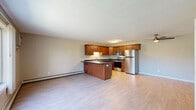 Located at 6788 Vicksburg Ln N in Maple Grove, Minnesota, this two-bedroom, two-bathroom two-story home offers a practical and comfortable layout spread across two well-proportioned floors. The main level features an open-concept kitchen and living area with light hardwood-style flooring throughout. The kitchen is equipped with warm-toned wood cabinetry, dark countertops, a peninsula with additional prep space, and a full suite of stainless steel appliances including a refrigerator, range, microwave, and dishwasher. Large windows on the main level flood the space with natural light and provide pleasant views of the surrounding greenery. A closet and staircase connect the main floor to the upper level. The upper floor hosts both bedrooms, each featuring plush carpet, neutral-toned walls, and windows that bring in ample daylight. The spacious primary bedroom includes a ceiling fan and multiple windows offering outdoor views. The two bathrooms are cleanly finished, one featuring a wood vanity, light countertop, and a tub/shower combination, and the other a single vanity with light flooring. Baseboard heating is present throughout, and the textured ceilings add a classic touch to the overall design.
