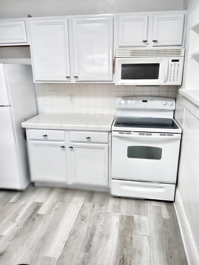 Kitchen with stove, refrigerator, microwave, dishwasher and sink - 10008 N Pawnee Ave