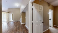 Located at 5009 Park Central Dr in Orlando, FL, this 2-bedroom, 1-bathroom single-story home offers a well-designed layout with thoughtful finishes throughout. The open living and dining area is a standout feature, boasting soaring vaulted ceilings, a ceiling fan, and rich wood-look flooring that extends throughout the main living spaces. Large windows allow generous natural light to fill the room, while a sliding glass door leads to an outdoor patio, bringing in views of the surrounding greenery.

The kitchen is efficiently laid out with white cabinetry, dark granite-style countertops, a stainless steel refrigerator, and a full suite of appliances including a dishwasher and electric range. A pass-through opening connects the kitchen to the living area, enhancing the open feel of the space.

Both bedrooms are carpeted and equipped with ceiling fans, providing a comfortable retreat. The primary bedroom includes a sliding glass door to the patio and a spacious closet. The secondary bedroom receives natural light through a window with blinds.

The bathroom features a white vanity with dark countertops, a large mirror, and a tub-shower combination, all finished with the same wood-look flooring found throughout the home. A hallway connects all rooms, completing this cohesive and functional floor plan.
