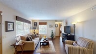 Located at 420 Munroe Falls Ave in Cuyahoga Falls, Ohio, this well-appointed single-floor residence offers one bedroom, two bathrooms, and a thoughtfully organized layout that maximizes every square foot. The inviting living room features rich hardwood-style flooring, a textured ceiling, and large windows that allow natural light to fill the space, creating a warm and comfortable atmosphere. A central hallway connects the main living areas and leads seamlessly to the private bedroom. The combined dining room and kitchen area is both practical and efficient. The galley-style kitchen is outfitted with white cabinetry, granite-style countertops, and black appliances, while the adjacent dining space provides a cozy setting for everyday meals. The generously sized primary bedroom is carpeted for comfort and includes a window with natural light. A dedicated office provides a quiet, functional workspace with its own warm lighting and carpeted flooring. Two full bathrooms serve the home, each with tub-shower combinations and hardwood-style flooring. In-unit laundry adds everyday convenience. Throughout the residence, consistent finishes, neutral tones, and cohesive design elements contribute to an overall ambiance that is practical, comfortable, and move-in ready.