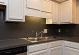 Located at 1941 20th Avenue Dr NE in Hickory, NC, this two-story home offers three bedrooms, two bathrooms, and a practical layout spread across two well-proportioned floors. The main floor houses the primary living areas, including a combined kitchen and living room, an entrance, and a hallway connecting the spaces. The living room features wood-look laminate flooring in a warm gray tone and a sliding glass door that invites natural light and provides access to an outdoor area. The kitchen is equipped with white upper cabinetry, dark countertops, stainless and black appliances including an electric range and refrigerator, and a window that brightens the dining area.

The upper floor contains all three bedrooms and the hallway, with plush gray carpet throughout the bedrooms. The generously sized primary bedroom includes two windows for natural light and a built-in closet. Additional bedrooms are comfortably sized with closet access. Both bathrooms feature white vanity cabinetry, light countertops, tub-shower combinations, and wood-look flooring. Textured ceilings are consistent throughout, and neutral wall tones create a clean, cohesive aesthetic across the entire home.