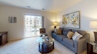 Located at 2601–2607 Lillian Ln in Beavercreek, Ohio, this single-floor residence offers a thoughtfully designed layout that balances comfort and functionality. The living room is a welcoming centerpiece, featuring plush carpeting, soft neutral walls, and a large sliding glass door that opens to a private balcony, flooding the space with natural light and offering views of the surrounding community. Adjacent to the living area, the dining space provides an intimate setting for meals, situated just steps from the kitchen. The kitchen is well-equipped with warm wood cabinetry, stone-toned countertops, stainless steel appliances including a range, over-the-range microwave, and dishwasher, along with tile flooring that adds a durable and clean finish. The primary bedroom is a serene retreat with carpeted floors, a window drawing in natural light, and ample space for furnishings. A second bedroom offers additional flexibility with its own window and comfortable layout. Two bathrooms serve the unit, each featuring wood-toned vanities and tile flooring; one includes a walk-in shower with glass sliding doors and built-in shelving. The unit also includes in-unit laundry, completing a practical and comfortable living experience.