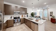 This single-floor residence in Huntersville, NC offers a thoughtfully designed layout that maximizes its efficient footprint. The open-concept living area seamlessly connects the kitchen, dining, and living spaces, creating a cohesive and functional environment. The kitchen is a standout feature, boasting rich dark-wood cabinetry, subway tile backsplash, stainless steel appliances including a range, microwave, dishwasher, and refrigerator, and a granite-topped island with pendant lighting overhead. The island doubles as a dining bar, providing casual seating for multiple guests.

The living room receives natural light through a full-length glass door, complemented by light wood-style flooring throughout the main areas. The bedroom features plush carpeting, a ceiling fan, and a window with natural light. It is served by a bathroom with a granite vanity, dark-framed mirror, and wood-tone cabinetry. A dedicated walk-in closet includes wire shelving and hanging rods for organized storage. Additional doors off the main hallway provide access to the second bathroom and closet spaces, all finished with consistent light wood flooring and clean white walls throughout.