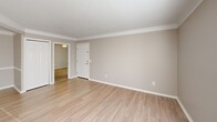 Located at 1061 Johnnie Dodds Blvd in Mount Pleasant, SC, this single-floor, 2-bedroom, 2-bathroom residence offers a well-organized layout designed for comfortable everyday living. The living room is bright and welcoming, featuring light hardwood-style flooring, crown molding, a textured ceiling, and large corner windows that flood the space with natural light. A sliding glass door provides direct access to an outdoor area, enhancing the open feel of the room. The kitchen is efficiently designed with warm honey-toned cabinetry, granite-style countertops, black appliances including a refrigerator, electric range, and dishwasher, and a peninsula that creates a natural division between the kitchen and living areas. Both bedrooms are carpeted and equipped with ceiling fans and windows that bring in natural light. The primary bedroom is generously sized and includes a dedicated closet. The two bathrooms each feature a tub/shower combination with white tile surrounds, complemented by wood-style flooring and neutral wall tones. Throughout the residence, a consistent neutral color palette and clean finishes create a cohesive and move-in-ready atmosphere, well-suited for those seeking a practical home in the heart of Mount Pleasant.