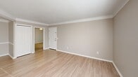 Located at 1061 Johnnie Dodds Blvd in Mount Pleasant, SC, this single-floor, 2-bedroom, 2-bathroom residence offers a well-organized layout designed for comfortable everyday living. The living room is bright and welcoming, featuring light hardwood-style flooring, crown molding, a textured ceiling, and large corner windows that flood the space with natural light. A sliding glass door provides direct access to an outdoor area, enhancing the open feel of the room. The kitchen is efficiently designed with warm honey-toned cabinetry, granite-style countertops, black appliances including a refrigerator, electric range, and dishwasher, and a peninsula that creates a natural division between the kitchen and living areas. Both bedrooms are carpeted and equipped with ceiling fans and windows that bring in natural light. The primary bedroom is generously sized and includes a dedicated closet. The two bathrooms each feature a tub/shower combination with white tile surrounds, complemented by wood-style flooring and neutral wall tones. Throughout the residence, a consistent neutral color palette and clean finishes create a cohesive and move-in-ready atmosphere, well-suited for those seeking a practical home in the heart of Mount Pleasant.