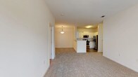 Located at 2100 Shiloh Valley Dr in Kennesaw, Georgia, this single-floor residence offers a clean, open-concept layout designed for comfortable everyday living. The living and dining areas flow seamlessly together, finished with plush wall-to-wall carpeting and neutral white walls that create a bright, welcoming atmosphere. Natural light filters in through multiple windows, enhancing the airy feel of the space.

The kitchen is a functional highlight, featuring white shaker-style cabinetry, granite countertops, a classic tile backsplash, and a full suite of stainless steel appliances including a range, over-the-range microwave, dishwasher, and refrigerator. A breakfast bar with a granite overhang connects the kitchen to the living area, ideal for casual dining. Wood-look flooring grounds the kitchen space.

The bedrooms are generously proportioned, each with soft carpeting, ample natural light, and ceiling fans where applicable. One bedroom includes direct exterior door access, adding a convenient private entry point.

The bathrooms are thoughtfully appointed. The primary bath features a dual-sink vanity with granite countertops, wood-look flooring, and a large mirror with overhead lighting. A secondary bath includes a full soaking tub with white tile surround. Throughout, the space maintains a cohesive, well-maintained aesthetic.