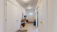 Located at 25 Silverlight Way in Rochester, NY, this two-bedroom, two-bathroom home spans two floors of thoughtfully arranged living space, complete with a garage and basement. The main floor features an open-concept layout combining the kitchen, dining room, and living room. The kitchen is well-appointed with warm wood cabinetry, stainless steel appliances including a French door refrigerator, electric range, and built-in microwave, all complemented by granite countertops and tile flooring. A breakfast bar adds casual seating, while track lighting keeps the space bright. The dining area enjoys abundant natural light through a large sliding glass door, accented by a classic chandelier overhead. The living room features hardwood flooring and vaulted ceilings, lending an open, airy feel. A welcoming entryway with tile flooring provides a practical transition space. Upstairs, the two bedrooms are carpeted and offer natural light through sizable windows. The bathrooms feature tile flooring, vanity storage, and tub/shower combinations. The attached garage provides generous vehicle and storage space with an automatic opener. A basement and utility room round out the home's functional layout, offering additional storage and utility access.