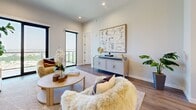 Located at 3111 Sunset Blvd in Flower Mound, TX, this thoughtfully designed one-bedroom, three-bathroom residence offers a refined living experience across a well-appointed single floor. The open-concept layout maximizes the sense of space, seamlessly connecting the living room, dining area, and kitchen. The living room is bathed in natural light from large floor-to-ceiling windows that frame panoramic views of the surrounding area, complemented by hardwood flooring and recessed lighting throughout. The kitchen features crisp white shaker cabinetry extending to the ceiling, a classic subway tile backsplash, light quartz countertops, and a full suite of stainless steel appliances, including a French door refrigerator and gas range. The spacious primary bedroom offers impressive elevated views through a large window and provides direct access to an en-suite bathroom. The bathrooms are finished with striking marble-look tile flooring, dark navy vanities adorned with brushed gold hardware, and backlit LED mirrors. A dedicated walk-in closet includes built-in shelving and dual hanging rails for ample storage. Additional conveniences include an in-unit laundry room with a front-load washer and dryer, as well as a private balcony accessible from the living area.