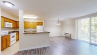 Located at 7120 Society Dr in Claymont, Delaware, this single-floor, three-bedroom, two-bathroom home offers a practical and comfortable layout. The open-concept living and dining area features durable hardwood-style flooring and a large sliding glass door dressed with vertical blinds, allowing abundant natural light and outdoor views to fill the space. A pendant light fixture adds a decorative touch overhead.

The kitchen is well-appointed with warm honey-toned wood cabinetry, dark granite-style countertops, tile flooring, and a full suite of white appliances including a range, built-in microwave, dishwasher, and refrigerator. A breakfast bar peninsula connects the kitchen to the living area, enhancing the open flow.

The spacious primary bedroom is carpeted and features two closets — one a sliding-door wardrobe and another additional storage space — along with a window providing natural light. The additional bedrooms are also carpeted and similarly bright. One bathroom includes a walk-in glass-enclosed shower with tile surround and a white vanity, while the second bathroom features a full soaking tub with white tile surround. Both bathrooms are finished with light tile flooring. The overall palette of warm neutrals and clean white trim creates a cohesive, move-in ready feel throughout the home.