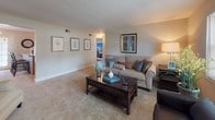 Located at 248 Presidential Dr in Wilmington, Delaware, this single-floor home offers a well-organized layout with comfortable living spaces throughout. The living room is generously sized, featuring neutral-toned carpet, warm lighting, and multiple windows that invite natural light, creating an inviting atmosphere anchored by classic furnishings and tasteful wall art. Adjacent to the living room, the dining area accommodates a full dining set and is accented by colorful artwork, providing a welcoming space for meals and gatherings. The kitchen is equipped with oak cabinetry, a granite-patterned peninsula with bar seating, hardwood flooring, and white appliances including a range, dishwasher, and refrigerator — a practical and efficient workspace. The primary bedroom features elegant four-poster spool beds, plush carpeting, ceiling fans, and windows with blinds offering natural light and privacy. A secondary bedroom is thoughtfully arranged as a children's room, complete with a loft-style bed frame and storage solutions. The full bathroom includes a tub-shower combination, a wood-toned vanity, tile flooring, and a window for ventilation. Overall, the home presents a warm, functional, and family-friendly environment.