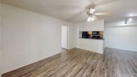 This 830 square foot apartment at Lakewood Place offers a well-designed living space with two bedrooms and two bathrooms. The unit features a modern, open-concept layout with a combined kitchen and living area. The kitchen is equipped with wood cabinetry, dark countertops, and black appliances, providing both functionality and style. Throughout the apartment, wood-look flooring adds warmth and durability.

The primary bedroom, measuring 150 square feet, offers ample space for a comfortable retreat. Both bathrooms are fitted with essential fixtures, including a bathtub-shower combination, and vanities with storage. The unit includes a convenient in-unit laundry area with a full-sized washer and dryer.

Large windows in the living area and bedrooms allow for natural light, while ceiling fans help maintain a comfortable temperature. The apartment also features spacious closets and additional storage areas. A sliding glass door leads to an outdoor space, offering a connection to the exterior environment. The overall design prioritizes efficiency and comfort in a compact yet well-appointed living space.