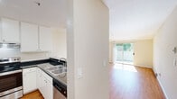 Located at 455 Brahms Way in Sunnyvale, California, this one-bedroom, one-bathroom residence offers a well-designed single-floor layout with consistent warm-toned hardwood flooring throughout. The open-concept living area is bright and airy, benefiting from a sliding glass door that leads to a private balcony, allowing natural light to flood the interior and providing pleasant outdoor views of the surrounding greenery. Ceiling fans are featured in both the living area and bedroom, adding to the comfort of the space.

The kitchen is thoughtfully designed with an open, peninsula-style layout featuring dark granite countertops, white cabinetry extending to the ceiling for ample storage, and stainless steel appliances including a refrigerator and electric range. The peninsula seamlessly connects the kitchen to the living area, making it ideal for everyday functionality.

The bedroom offers a comfortable footprint with mirrored sliding closet doors, a ceiling fan, and a baseboard heating system. Neutral walls throughout the home provide a clean, versatile backdrop. The bathroom is finished with dark granite countertops, white cabinetry, hardwood-style flooring, and a well-lit vanity mirror. Baseboard heaters are present across multiple rooms, ensuring consistent warmth throughout the home.
