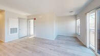Located at 340 Driftway in coastal Scituate, Massachusetts, this thoughtfully designed two-bedroom, two-bathroom residence offers a clean, contemporary aesthetic throughout its single-floor layout. Light-toned hardwood flooring runs continuously across all rooms, unifying the space and enhancing its bright, airy character.

The open-concept kitchen is a standout feature, outfitted with white shaker cabinetry, dark quartz countertops, a full suite of stainless steel appliances including a refrigerator, electric range, microwave, and dishwasher, plus a movable island that adds flexible prep and dining space. Track and recessed lighting illuminate the kitchen effectively.

The living room is generously proportioned, filled with natural light from multiple windows and a glass sliding door that opens to a private balcony with outdoor views. Both bedrooms are well-sized, featuring light-filled windows and continued hardwood flooring. The primary bedroom includes a dedicated walk-in closet with wire shelving systems.

The two bathrooms each feature distinct designs: one includes a glass-enclosed shower with gold-toned hardware and a backlit vanity mirror, while the second offers a full soaking tub and shower combination. Both bathrooms maintain the residence's clean, modern palette.