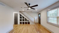 Located at 3170 Alston Dr. in Decatur, GA, this two-story, two-bedroom, three-bathroom unit offers a thoughtfully designed layout spread across two floors. Warm natural hardwood flooring flows consistently throughout, complemented by crisp white walls and a clean, modern aesthetic.

The main floor houses the kitchen, a bathroom, and the primary living areas. The kitchen is well-appointed with light wood cabinetry, white quartz countertops, stainless steel appliances including a gas range and French door refrigerator, open shelving, and a single-basin sink with a matte black faucet. Recessed lighting and a window bring brightness to the space.

The bathrooms are finished with contemporary details, including speckled quartz vanity tops, matte black fixtures, framed mirrors, and stylish accessories. One full bathroom features striking dark hexagonal floor tiles, white subway tile walls with a contrasting accent stripe, a soaking tub with a glass enclosure, and a window for natural light.

Both bedrooms are located on the upper floor and feature hardwood flooring, ceiling fans with integrated lighting, and natural light from windows. The spacious primary bedroom includes a double-door closet with charcoal-toned craftsman-style doors. Each bedroom offers a calm, comfortable atmosphere with clean finishes throughout.