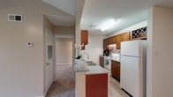 Located at 111 Edie Ann Dr in Lafayette, Louisiana, this single-floor residence offers a well-designed layout that balances comfort and functionality. The living area is a standout feature, boasting vaulted ceilings that lend an open, airy feel to the space, with plush carpeting underfoot and a ceiling fan providing year-round comfort.

The kitchen is thoughtfully appointed with rich, warm-toned cabinetry, granite-look countertops, a double stainless steel sink, a tile backsplash, and white appliances including a refrigerator and electric range. A built-in wine rack adds a distinctive touch. The peninsula design creates a natural connection between the kitchen and living area, making it ideal for everyday living and entertaining.

The bedrooms are generously proportioned, each featuring soft carpeting, natural light from windows, and ceiling fans. Ample storage is provided through a spacious walk-in closet fitted with wire shelving and hardwood-style flooring.

Both bathrooms are well-finished, featuring rich wood cabinetry, granite-look countertops, vessel-style sinks with modern brushed-nickel faucets, framed mirrors, and tub-shower combinations. Hardwood-style flooring completes each bathroom's polished look. Throughout the home, neutral tones and consistent finishes create a cohesive and inviting atmosphere.