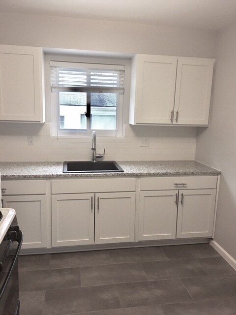 kitchen with new cabinets, tile, backsplash, and granite countertops - 717 Newport Pl