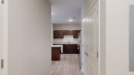 This single-floor residence offers a thoughtfully designed layout across two bedrooms and two bathrooms, making efficient use of its floor space. Light wood-style flooring runs throughout the living areas and bedrooms, complementing the neutral, warm-toned walls that create a clean and cohesive aesthetic.

The kitchen is a standout feature, equipped with rich dark-espresso cabinetry, granite-style countertops, a white subway tile backsplash, and a full suite of stainless steel appliances including a range, microwave, and dishwasher. The space is functional and well-organized, connecting naturally to the living area. The living room receives abundant natural light through large windows and a glass door, and is finished with a ceiling fan overhead.

The primary bedroom is generously sized, featuring a window with blinds and a dedicated walk-in closet with wire shelving. The primary bathroom includes a glass-enclosed walk-in shower with white subway tile and brushed nickel hardware. The second bathroom features a soaking tub and shower combination, tile flooring, a dark vanity, and granite-topped counters. Each room maintains a bright, move-in-ready appearance throughout.