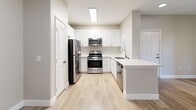 This well-appointed 5-bedroom, 3-bathroom single-floor unit at 25335 Alessandro Blvd in Moreno Valley, CA spans 940 square feet of thoughtfully designed living space. Consistent wood-look flooring flows throughout every room, complemented by neutral gray-toned walls and crisp white trim, creating a clean, cohesive aesthetic. The kitchen is a standout feature, showcasing white shaker cabinetry, light quartz countertops, stainless steel appliances including a gas range, microwave, dishwasher, and refrigerator, along with a skylight that brightens the space naturally. The adjacent living room offers a ceiling fan and a built-in desk nook. The primary bedroom measures 140 square feet and opens to a private balcony through sliding glass doors, with a ceiling fan and a dedicated walk-in closet featuring wire shelving. Additional bedrooms are bright and well-sized, each equipped with ceiling fans and windows offering outdoor views. The three bathrooms are finished with tub/shower combinations, wood-look flooring, and chrome fixtures. Two hallways connect the layout efficiently, and a dedicated closet provides additional storage. The unit combines functional design with modern finishes throughout.