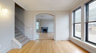 Located at 2599 Church Avenue in Cleveland, OH, this two-story home offers four bedrooms, two bathrooms, and an impressive total footprint spread across both levels. The lower floor features elegantly appointed living areas showcasing rich hardwood flooring, ornate crown molding, and a striking arched doorway that connects the main living spaces. A decorative marble fireplace serves as a focal point in one of the living rooms, adding timeless character alongside original ceiling medallions. Natural light flows in through multiple windows throughout.

The upper floor presents a more industrial aesthetic, with exposed beam ceilings, raw brick accent walls, and carpeted bedroom spaces that offer a warm contrast to the structural elements above. The generously sized primary bedroom includes built-in closet storage, while additional closets provide ample organization throughout. The well-appointed kitchen features rich cherry cabinetry, granite countertops, stainless steel appliances including a dishwasher and range, and tile flooring. The bathrooms are finished with matching cabinetry, granite vanities, and include exposed brick accents that tie into the building's character. A carpeted walk-in closet with wire shelving rounds out the functional storage offerings of this distinctive Cleveland home.