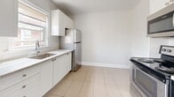 Located at 152 Dufferin Ave in Brantford, Ontario, this one-bedroom, one-bathroom unit offers a well-organized layout across a single floor. The combined living and dining area is a standout feature, showcasing gleaming hardwood floors that reflect generous natural light streaming through large windows. A radiator heating system provides reliable warmth, and a charming arched doorway adds a classic architectural detail to the space.

The kitchen has been thoughtfully renovated with crisp white shaker-style cabinetry, subway tile backsplash, stone-look countertops, and a full suite of stainless steel appliances including a refrigerator, dishwasher, and range. Light tile flooring and a window above the sink further brighten the space.

The bedroom is a comfortable, quiet retreat with warm hardwood floors, neutral walls, and a window with views of the surrounding neighbourhood. Two closets provide practical storage throughout the unit.

The bathroom is finished in a clean, all-white palette, featuring a tiled tub-shower combination, a vanity with ample counter space, and tile flooring. A hallway connects the rooms efficiently, completing a functional and well-appointed layout suited for comfortable everyday living.