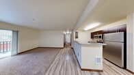 Located in Bothell, WA, this three-bedroom, two-bathroom residence offers a well-organized single-floor layout designed for comfortable everyday living. The open-concept kitchen and living area serves as the heart of the home, featuring light wood-style hard flooring, dark espresso cabinetry, stainless steel appliances including a refrigerator, stove, and microwave, and a peninsula counter that connects the kitchen to the living space. The living room is generously sized with plush carpet and a sliding glass door that opens to a private balcony. Each of the three bedrooms is carpeted and filled with natural light from large windows with views of the surrounding area. The primary bedroom includes a dedicated closet with built-in wire shelving, while an additional walk-in closet provides ample storage. Both bathrooms are finished with tile flooring, dark wood vanities with wide countertops, and full-size soaking tubs with shower combinations. Two hallways connect the rooms efficiently throughout the unit. The neutral warm color palette and consistent finishes create a clean, cohesive atmosphere throughout the entire residence.