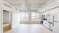 Located at 1901 Callowhill St in Philadelphia's Callowhill neighborhood, this one-bedroom, one-bathroom unit offers a well-designed layout with contemporary finishes throughout. The open living and kitchen area is defined by striking exposed concrete ceilings and light wood-look flooring, creating an industrial-modern aesthetic. Large windows flood the space with natural light and frame impressive views of the Philadelphia skyline and surrounding cityscape.

The kitchen features white shaker cabinetry, a subway tile backsplash, and a full suite of stainless steel appliances including a range, microwave, dishwasher, and refrigerator. The living area benefits from expansive floor-to-ceiling windows with roller shades, offering both abundant light and privacy.

The bedroom is a bright, intimate space with its own window showcasing city views, light wood flooring, and the same exposed concrete ceiling detail that carries throughout the unit. The bathroom is finished in crisp white tones with large-format tile flooring, a single vanity with under-cabinet storage, and a tub-shower combination with elegant marble-style tile surround. A utility room completes the layout. This unit combines urban industrial character with clean, modern design in a prime Philadelphia location.