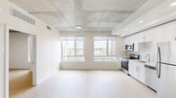 Located at 1901 Callowhill St in Philadelphia's Callowhill neighborhood, this one-bedroom, one-bathroom unit offers a well-designed layout with contemporary finishes throughout. The open living and kitchen area is defined by striking exposed concrete ceilings and light wood-look flooring, creating an industrial-modern aesthetic. Large windows flood the space with natural light and frame impressive views of the Philadelphia skyline and surrounding cityscape.

The kitchen features white shaker cabinetry, a subway tile backsplash, and a full suite of stainless steel appliances including a range, microwave, dishwasher, and refrigerator. The living area benefits from expansive floor-to-ceiling windows with roller shades, offering both abundant light and privacy.

The bedroom is a bright, intimate space with its own window showcasing city views, light wood flooring, and the same exposed concrete ceiling detail that carries throughout the unit. The bathroom is finished in crisp white tones with large-format tile flooring, a single vanity with under-cabinet storage, and a tub-shower combination with elegant marble-style tile surround. A utility room completes the layout. This unit combines urban industrial character with clean, modern design in a prime Philadelphia location.
