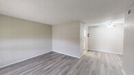 This 700 square foot single-story residence in Clute, Texas offers a well-designed living space with two bedrooms and one bathroom. The home's layout includes a living room, kitchen, and hallway, efficiently utilizing the available space.

The property features a mix of modern gray wood-look flooring and plush carpeting, creating a contemporary aesthetic throughout. Large windows in the living areas and bedrooms allow ample natural light to flood the space, enhancing the sense of openness. Ceiling fans with integrated lighting fixtures are present in multiple rooms, providing both illumination and air circulation.

The primary bedroom, measuring 150 square feet, offers a generous space for relaxation. Both bedrooms feature neutral-toned walls and carpeted floors, creating a cozy atmosphere. The kitchen, while compact, includes modern appliances and ample counter space for meal preparation.

The bathroom, though not extensively detailed in the images, appears to have updated fixtures and continues the home's modern design theme. The living room serves as the central hub of the home, with its open layout ideal for entertaining or everyday living.

Overall, this property presents a well-maintained, contemporary living space that maximizes functionality within its 700 square foot footprint. Its location at 101 Hackberry St in Clute, TX, adds to its appeal for those seeking a modest yet comfortable home in this area.