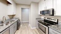 Located at 102 Brentway Cir in Knoxville, TN, this well-appointed one-bedroom, one-bathroom unit offers a thoughtfully designed single-floor layout. Wood-look luxury flooring flows consistently throughout every room, complemented by neutral warm-gray walls and crisp white trim, creating a clean and cohesive aesthetic.

The welcoming entrance leads into a hallway lined with closet storage before opening to the spacious living room, which features a ceiling fan with light fixture and connects seamlessly to the combined dining and kitchen area. The kitchen is well-equipped with white shaker-style cabinetry, granite-look countertops, stainless steel appliances including a range, microwave, and refrigerator, and convenient in-unit washer and dryer. A pantry and utility room provide additional storage and functionality.

The generously sized bedroom offers ample floor space, a ceiling fan, a window with natural light, and closet access. The full bathroom is finished with a gray vanity, granite countertop, framed mirror, and a tub-shower combination with tile surround. Three closets throughout the unit ensure plentiful storage. The overall layout is efficient and practical, making excellent use of the available space.
