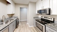 Located at 102 Brentway Cir in Knoxville, TN, this well-appointed one-bedroom, one-bathroom unit offers a thoughtfully designed single-floor layout. Wood-look luxury flooring flows consistently throughout every room, complemented by neutral warm-gray walls and crisp white trim, creating a clean and cohesive aesthetic.

The welcoming entrance leads into a hallway lined with closet storage before opening to the spacious living room, which features a ceiling fan with light fixture and connects seamlessly to the combined dining and kitchen area. The kitchen is well-equipped with white shaker-style cabinetry, granite-look countertops, stainless steel appliances including a range, microwave, and refrigerator, and convenient in-unit washer and dryer. A pantry and utility room provide additional storage and functionality.

The generously sized bedroom offers ample floor space, a ceiling fan, a window with natural light, and closet access. The full bathroom is finished with a gray vanity, granite countertop, framed mirror, and a tub-shower combination with tile surround. Three closets throughout the unit ensure plentiful storage. The overall layout is efficient and practical, making excellent use of the available space.