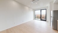 Located at 4080 32nd St in San Diego's vibrant North Park neighborhood, this thoughtfully designed unit offers a clean, modern aesthetic throughout its single-floor layout. Light wood-tone flooring runs continuously across the space, lending warmth and visual cohesion to every room.

The kitchen is a standout feature, outfitted with contemporary flat-front cabinetry in a warm wood finish, white quartz countertops, and a soft green subway tile backsplash. Stainless steel appliances include a gas range, over-the-range microwave, dishwasher, and a full-size refrigerator, providing a fully functional cooking space.

The main living area is bright and open, finished with crisp white walls and recessed lighting. A full-height glass sliding door leads to a private balcony, inviting natural light deep into the room while offering views of the surrounding San Diego neighborhood, including glimpses of palm trees and neighboring rooftops.

The bathroom is finished in a clean, all-white palette with subway tile surrounding a full soaking tub and shower combination. Matte black fixtures and hardware provide a contemporary contrast, adding a refined design touch. Light wood flooring continues here, maintaining consistency with the rest of the unit. Overall, the space delivers a modern and functional living environment in a desirable urban location.